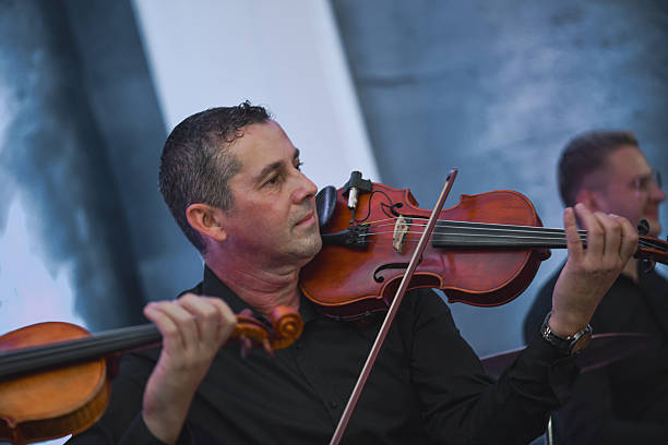 istock Violinist Smiling During a Live Music Session With Ensemble and Bow in Hand 2245319762