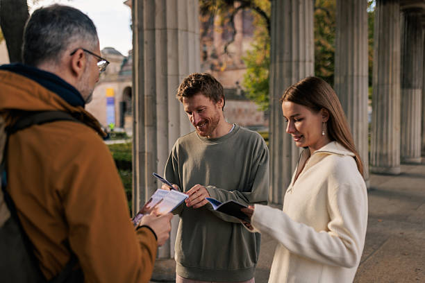istock Tourist Couple Talking With Tour Guide 2245321793