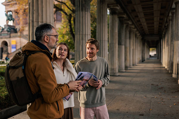 istock Tourist Couple Talking With Tour Guide 2245321941