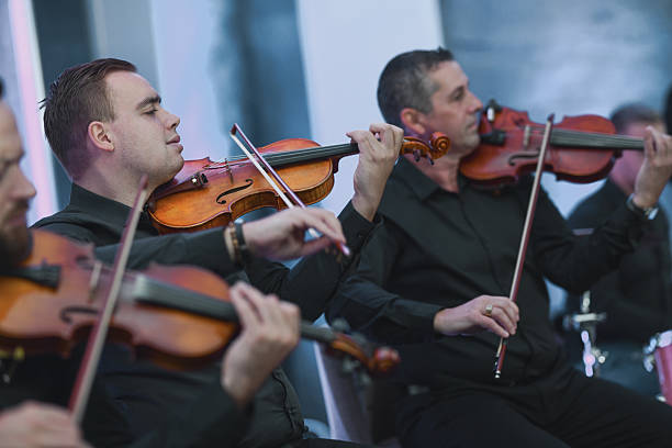 istock Violinists Playing in a Live Ensemble Session With Focused Expressions 2245322011