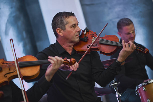 istock Violinist Smiling During a Live Music Session With Ensemble and Bow in Hand 2245322127