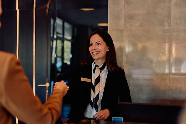 istock Hotel receptionist welcoming guest at check-in counter 2245323468
