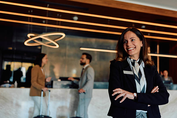 istock Professional hotel receptionist smiling at luxury lobby 2245323511
