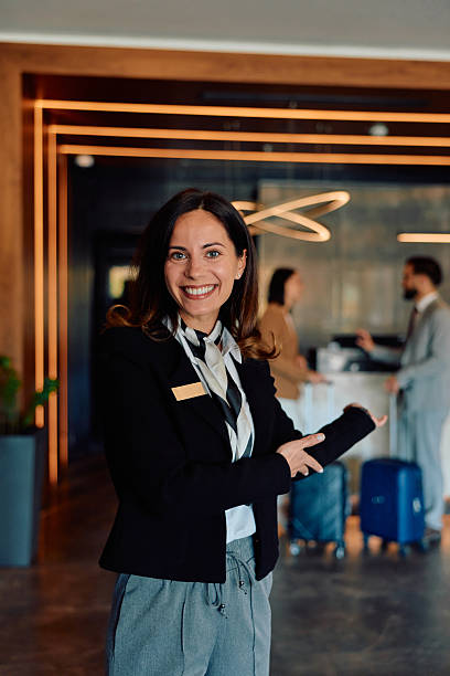 istock Smiling hotel receptionist welcoming guests to modern lobby 2245323547
