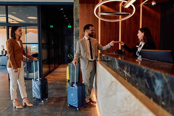 istock Couple checking in at hotel reception desk 2245323622