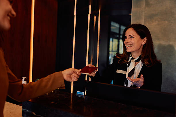 istock Hotel guest giving passport to smiling receptionist 2245323624