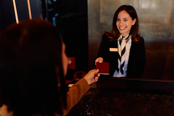 istock Hotel receptionist welcoming guest, handing over passport 2245323625