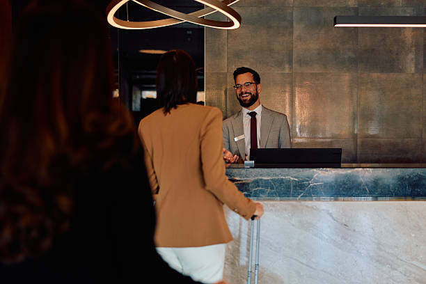 istock Smiling hotel concierge greeting female guest checking in 2245323810
