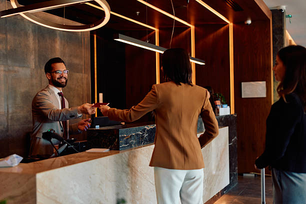 istock Hotel receptionist checking in guest holding passport 2245323832