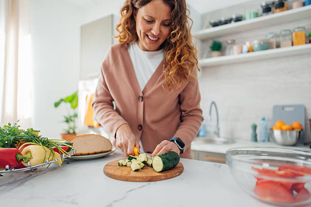 istock Woman Cooking with Fresh Vegetables in Modern Kitchen 2245324943