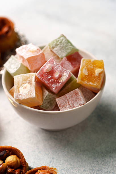 istock Colorful Turkish delight cubes arranged in a bowl with assorted snacks on a light surface 2245329300