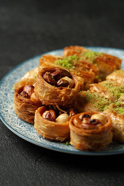 Traditional Middle Eastern sweets arranged on a decorative plate with nuts and syrup at a cultural gathering
