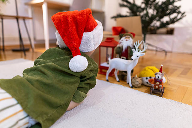istock Boy lying on the floor, looking at his Christmas decorations. 2245332118
