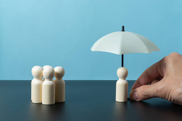 istock Wooden doll figures on light blue background. Insurance cover concept 2245336700