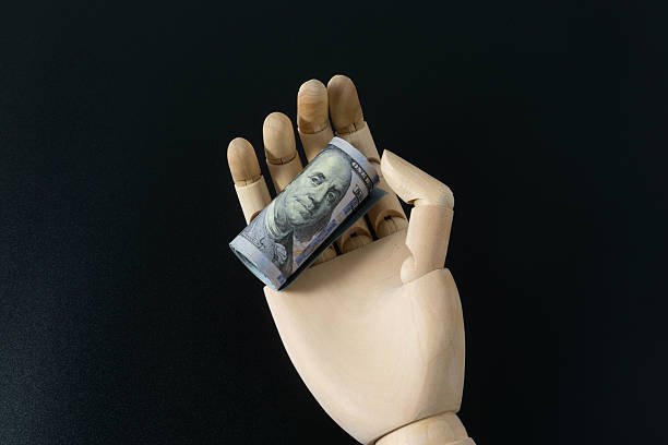 istock Wooden hand model and dollar banknote 2245336883