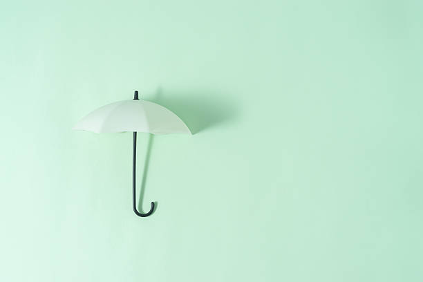 Umbrella toy on light green background with a copy space