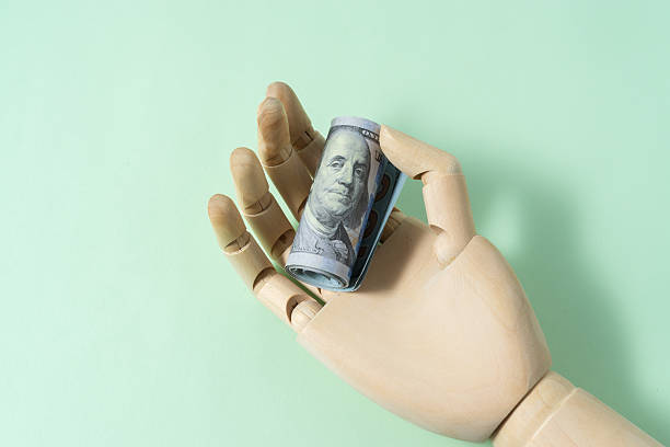 istock Wooden hand model holding dollar banknote 2245336971