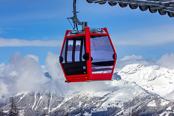 istock Red gondola ascending snowy Austrian mountains 2245337683