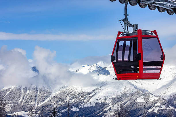 istock Red gondola ascending snowy Austrian mountains 2245337699
