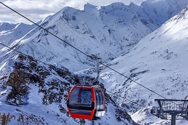 istock Red gondola ascending snowy Austrian mountains 2245337938