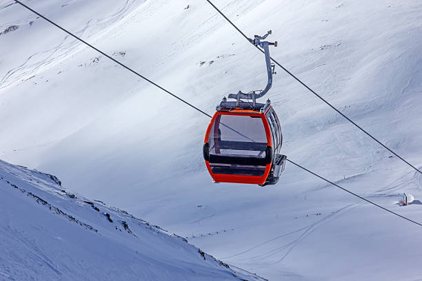 istock Red gondola ascending snowy Austrian mountains 2245337943
