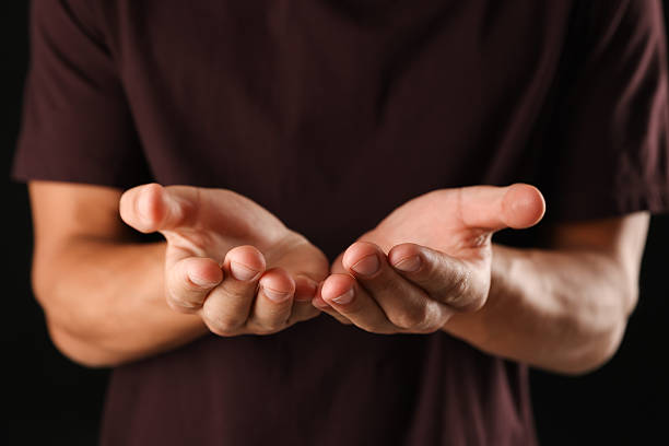 istock Man holding something on black background, closeup 2245338065