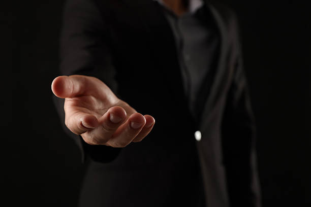 istock Man holding something on black background, closeup 2245339195