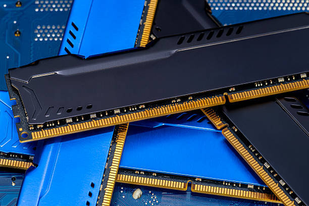 istock Four DDR memory chips in different colors lying on a blue printed circuit board. 2245339470