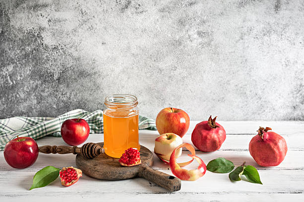 istock Apples, pomegranate and honey on a light rustic table. Jewish New Year, Rosh Hashanah. Side view, copy space 2245339509