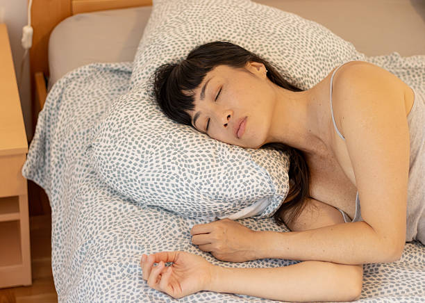 istock Woman sleeping soundly in bed getting rest 2245340925