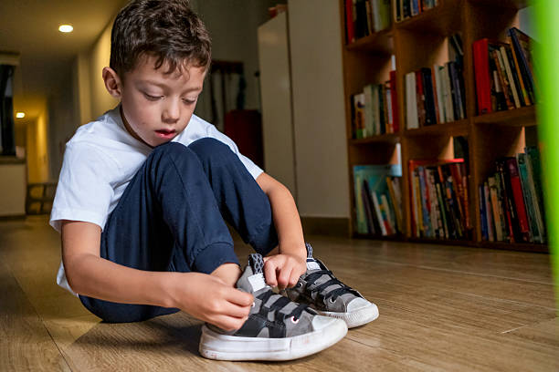 istock little boy learning to tie his shoelaces 2245341666