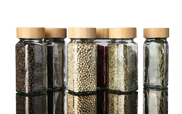 istock Many different aromatic spices in jars on mirror surface against white background 2245344731