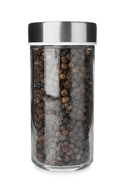 istock Black peppercorns in spice jar isolated on white 2245344739