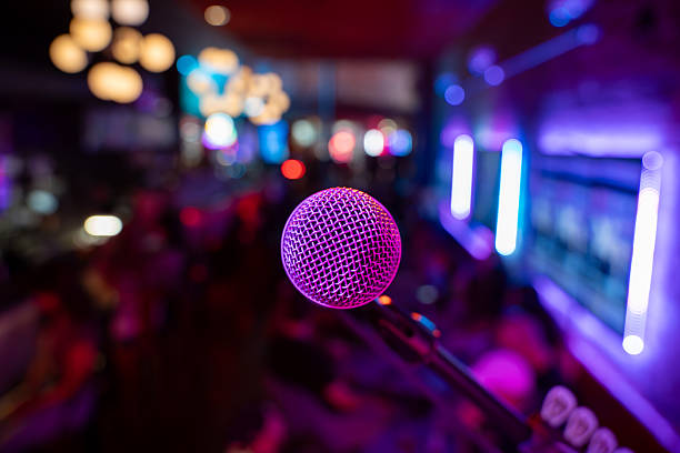 Close up of microphone in bar with blurred crowd in background.