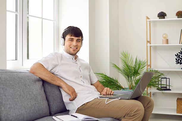 istock Cheerful male student freelancer at home watching online training or webinar on laptop. 2245345937