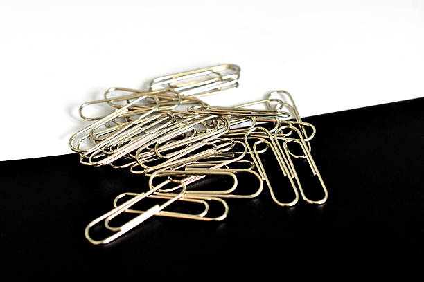 Paper clips for fixing sheets of paper on a black and white background.