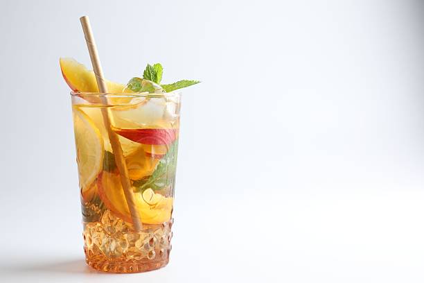 istock Tasty iced tea with lemon, peach and mint on white background, closeup. Space for text 2245347805