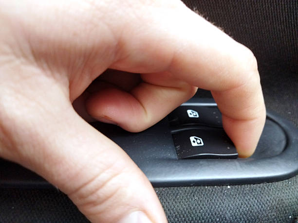 istock Hand adjusting car window controls in a vehicle interior 2245349816