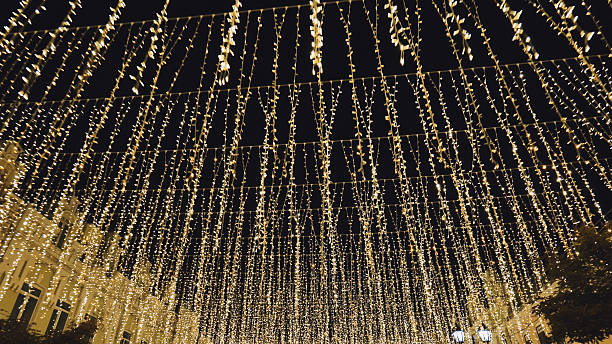 istock Glittering golden string lights draped across dark evening, casting warm, enchanting glow for festive holiday ambiance 2245350122