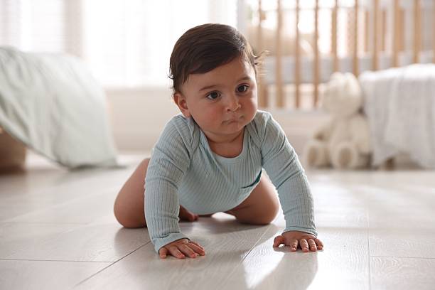 istock Cute little baby crawling on floor at home 2245351725