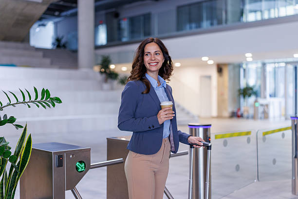 istock Smiling businesswoman accessing a secure office entrance with coffee 2245358213
