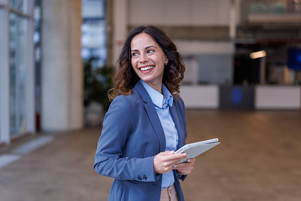 istock Businesswoman smiling holding tablet in modern office 2245358281