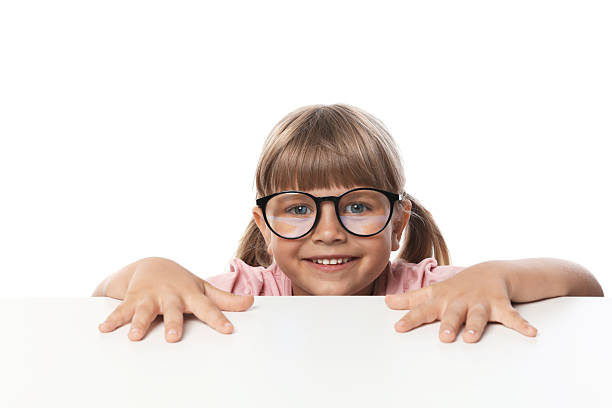 istock Curious little girl peeking in glasses over table against white background 2245369939