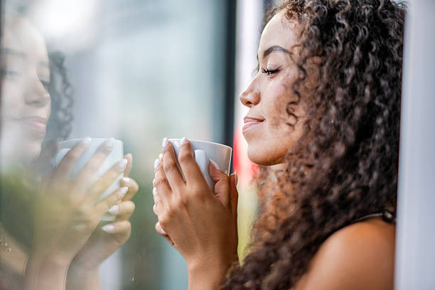 istock young woman drinking hot coffee while looking out the window 2245370238