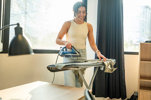 istock woman ironing comfortably from her apartment 2245370342