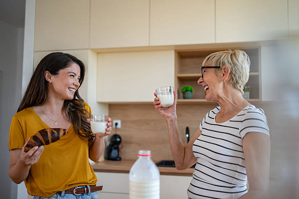 istock Mother and daughter laughing enjoying breakfast in kitchen 2245370698