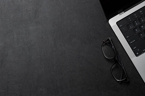 istock Office supplies and laptop on black leather workspace, top view with copy space 2245371295