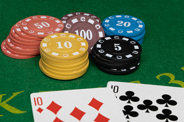 istock Poker chips and playing cards on green casino table 2245373530