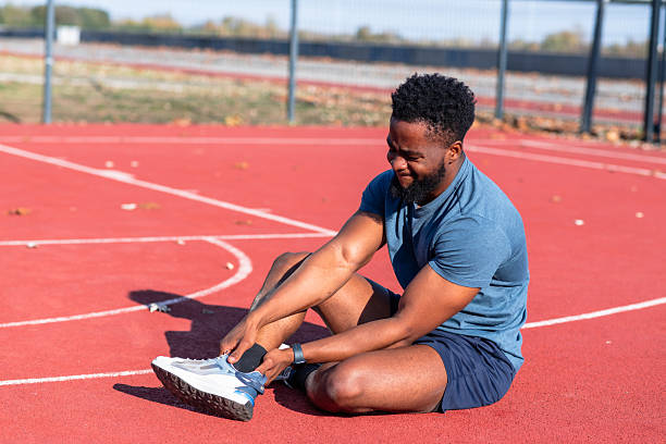 istock Young athlete sitting on court with ankle pain 2245373661