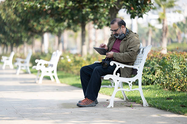 A man having fun outside in the park and using smart phone